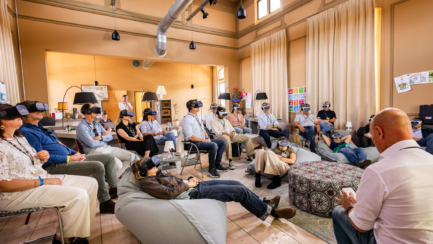 a group of people sitting in chairs with virtual reality goggles experience the overview effect